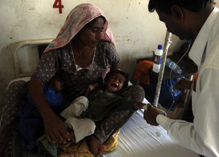 Một em bé theo gia đình chạy lụt đang được bác sỹ thăm khám ở Tando Allahyar , Sindh, Pakistan.